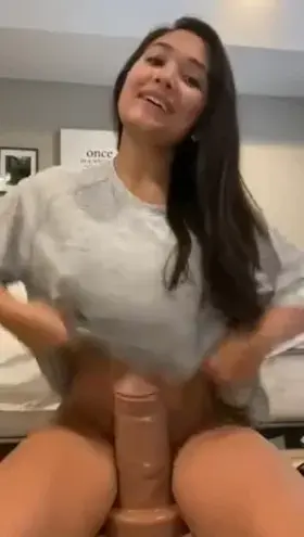 Who is this pierced nipple flasher hiding a dildo?