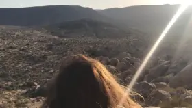 Bent over a rock in the desert.