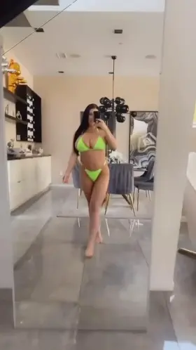 She checks herself in the mirror, then walks into the pool