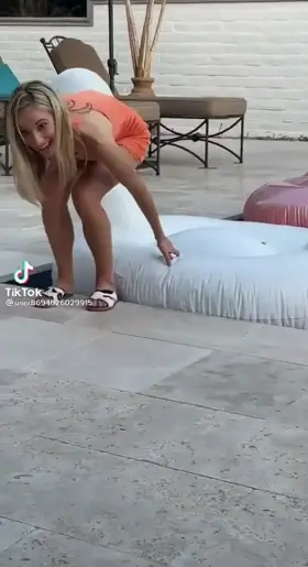 Blonde trying to sit on inflatable swan and flashing panties