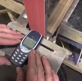 Nokia 3310 getting destroyed by belt sander