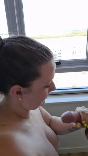 Sucking cock in front of the hotel window