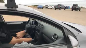 Playing with a dildo, windows down, in a crowded parking lot.