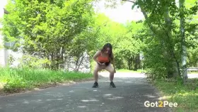 Brunette cutie lifts her skirt to relieve her piss desperation on a path